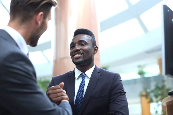 Reunión de negocios. Hombre de negocios afroamericano estrechando la mano con hombre de negocios caucásico. — Foto de Stock