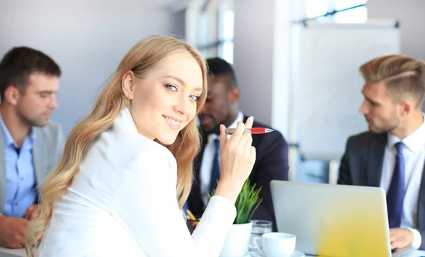 Mujer de negocios con su personal, el grupo de personas en segundo plano en la oficina brillante moderna en el interior. — Foto de Stock