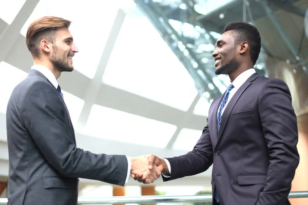 Business meeting. African American businessman shaking hands with caucasian businessman.