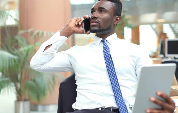 Empresario afroamericano exitoso usando tableta y hablando por teléfono . —  Fotos de Stock
