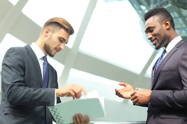 Dos jóvenes empresarios multinacionales discuten negocios en reunión en el cargo . — Foto de Stock