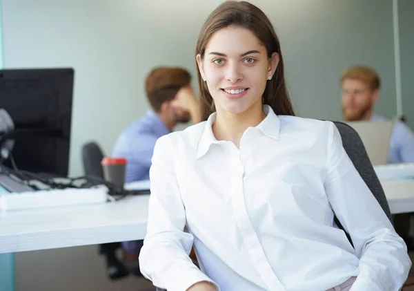 Geschäftsfrau mit ihren Mitarbeitern, Menschen im Hintergrund in modernen, hellen Büroräumen. — Stockfoto