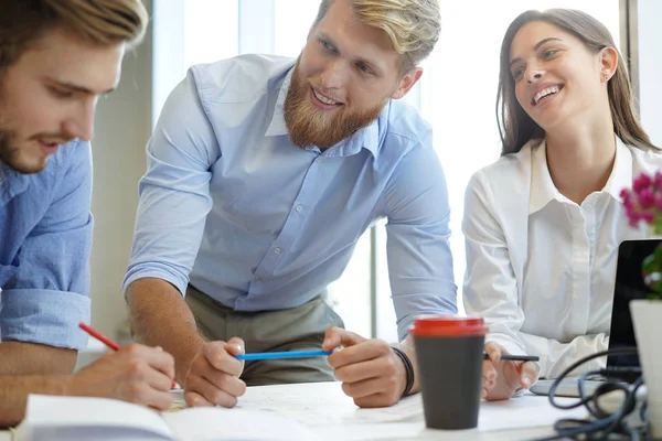 Jóvenes empresarios confiados discutiendo algo mientras miran el plano en la oficina, el equipo de arquitectura . —  Fotos de Stock