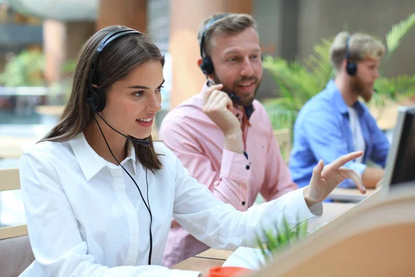 Attraente positivo giovani imprenditori e colleghi in un ufficio call center. — Foto Stock