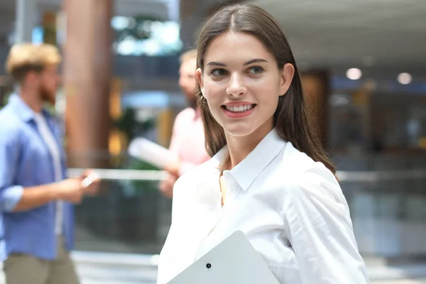 Femme d'affaires avec son personnel, groupe de personnes en arrière-plan au bureau lumineux moderne . — Photo