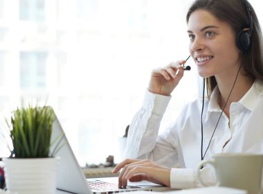 Kulaklıklı ve gülümseyen kadın müşteri destek operatörü.