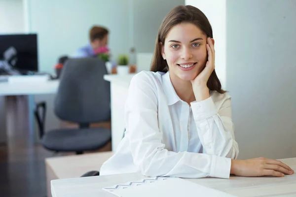 Affärskvinna med sin personal, människor grupp i bakgrunden på moderna ljusa kontor inomhus. — Stockfoto