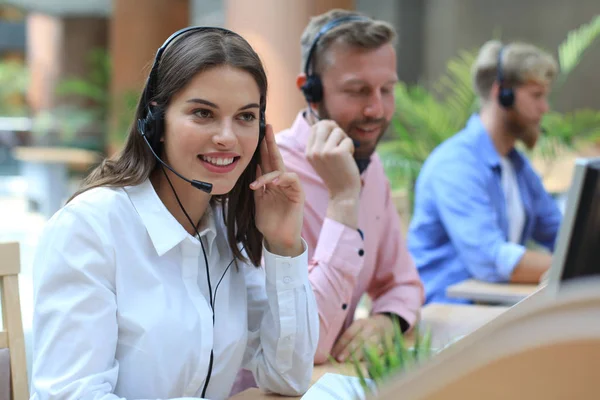 Aantrekkelijke jonge ondernemers en collega 's in een callcenter. — Stockfoto
