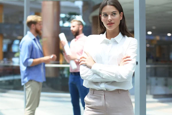 Zakenvrouw met haar medewerkers, mensen groep op achtergrond op moderne heldere kantoor. — Stockfoto