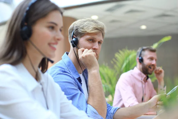 Attraente positivo giovani imprenditori e colleghi in un ufficio call center. — Foto Stock