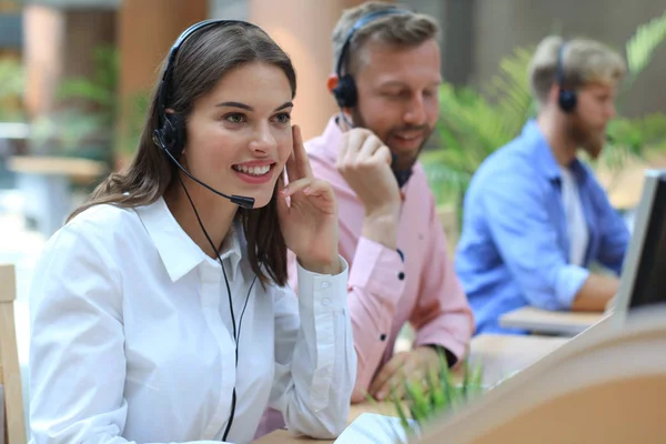 Atraktivní pozitivní mladí podnikatelé a kolegové v call centru. — Stock fotografie