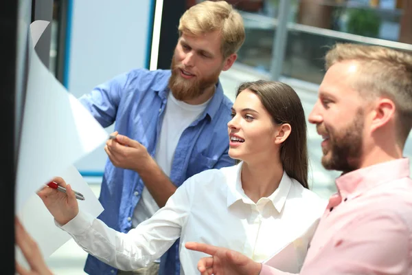 Grupo de jóvenes empresarios y diseñadores en ropa casual inteligente. Están trabajando en un nuevo proyecto . — Foto de Stock