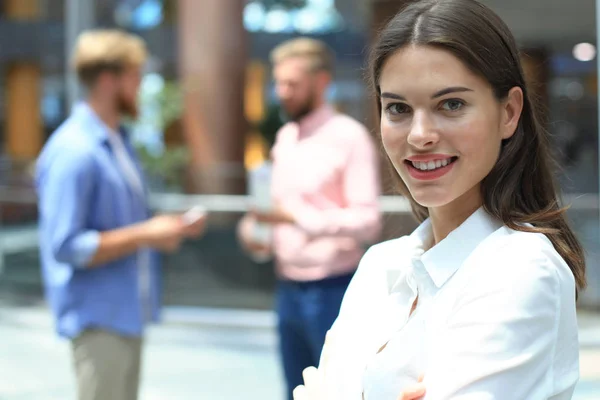 Mujer de negocios con su personal, grupo de personas en segundo plano en la oficina brillante moderna . —  Fotos de Stock