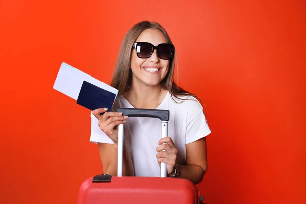 젊은 관광 여자 여름 캐주얼 옷, 선글라스, 레드 가방, 빨간 배경에 고립 된 여권. — 스톡 사진