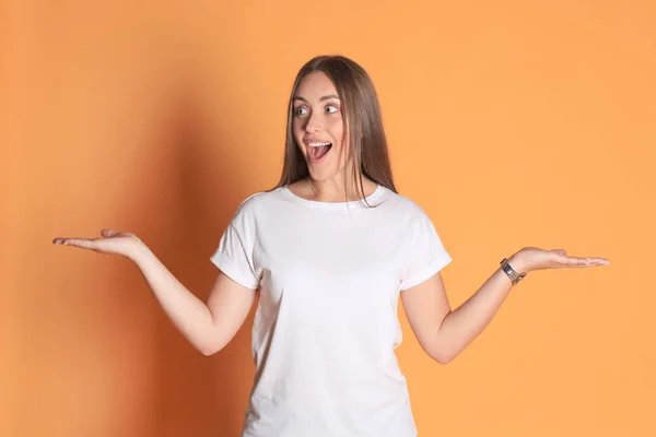 Jovem mulher em roupas casuais perguntando e gritando isolado sobre fundo amarelo . — Fotografia de Stock