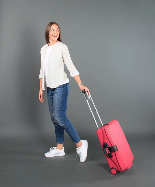 Kırmızı çanta, pasaport, Bilet üzerinde gri arka plan izole yaz casual giysili genç turist kızı. — Stok fotoğraf