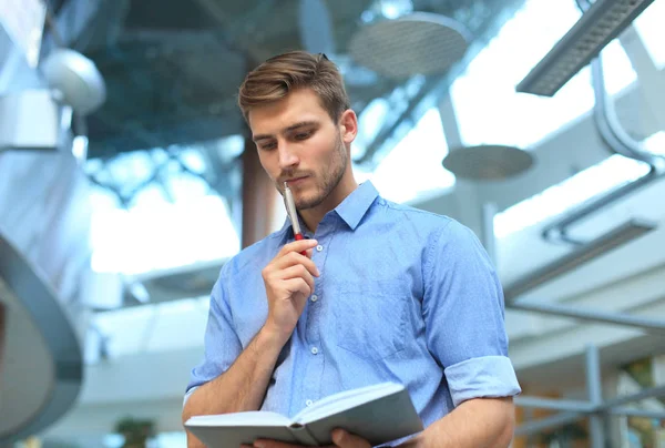 Pensive young man standing in his office.