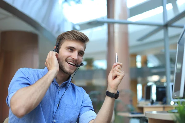 Freundlich lächelnde hübsche junge männliche Callcenter-Betreiber. — Stockfoto