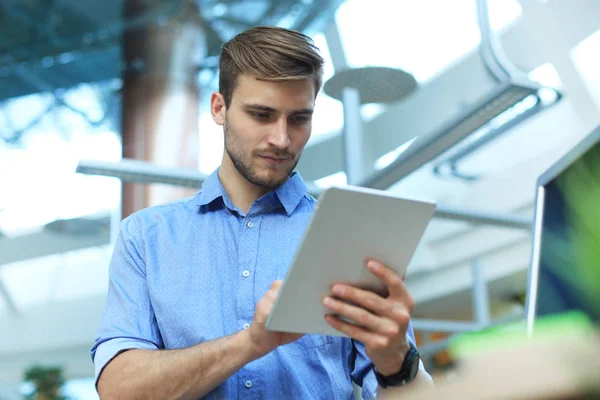 Jongeman met zijn tablet op kantoor. — Stockfoto