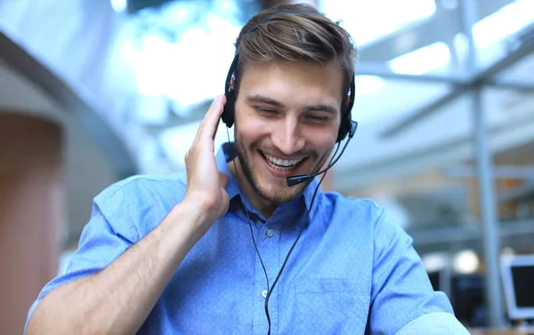 Freundlich lächelnde hübsche junge männliche Callcenter-Betreiber. — Stockfoto