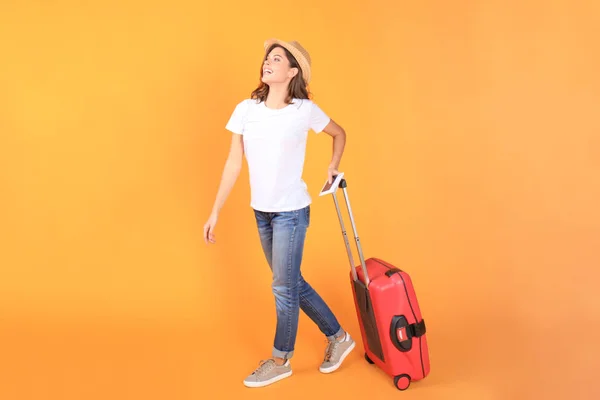 Jeune fille touristique en vêtements décontractés d'été, avec valise rouge, passeport, billets isolés sur fond beige . — Photo