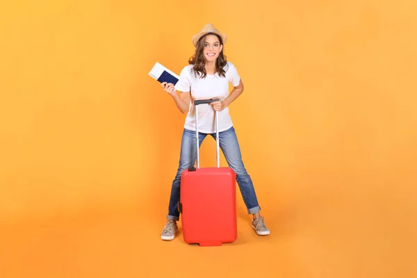 Jeune fille touristique en vêtements décontractés d'été, avec valise rouge, passeport, billets isolés sur fond beige . — Photo