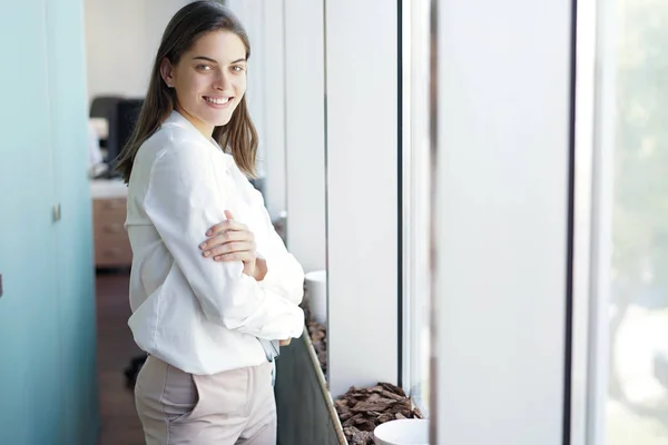 Belle dame d'affaires regarde la caméra et souriant tout en travaillant dans le bureau. — Photo