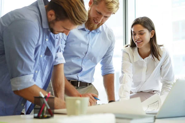 Ung självsäker business människor diskutera något medan du tittar på plan på kontoret, arkitekturen team. — Stockfoto