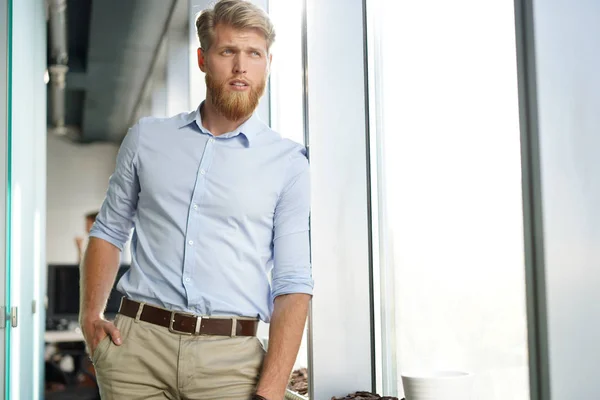 Portrait d'un jeune homme d'affaires décontracté heureux au bureau. — Photo