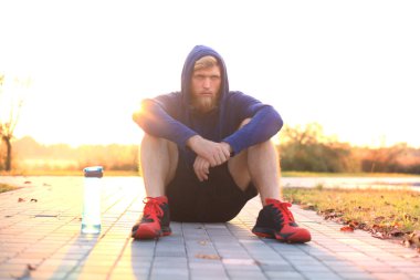 Parkta koşu gündoğumu veya günbatımı sonra dinlenme çalıştırdıktan sonra yakışıklı delikanlı.