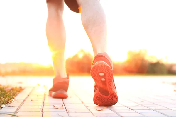 Pies de corredor corriendo por carretera primer plano en zapato, al aire libre al atardecer o al amanecer . — Foto de Stock