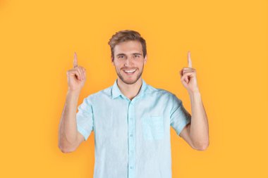 Mutlu delikanlı sarı arka plan işaret içinde izole poz.