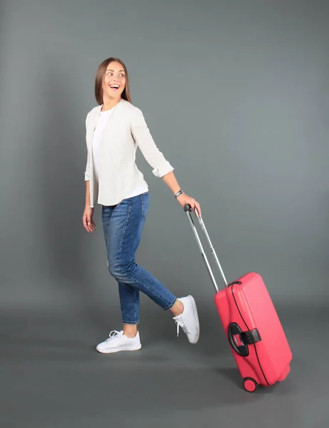 Jeune fille touristique en vêtements décontractés d'été, avec valise rouge, passeport, billets isolés sur fond gris . — Photo