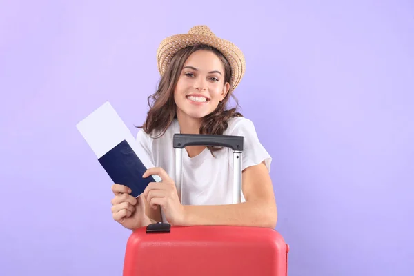 Jeune fille touristique en vêtements décontractés d'été, avec des lunettes de soleil, valise rouge, passeport isolé sur fond violet . — Photo
