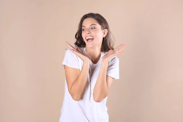 Jonge vrouw in casual kleding benieuwd en geïsoleerde schreeuwen over beige achtergrond. — Stockfoto
