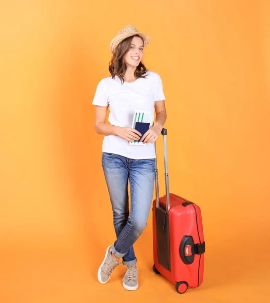 Menina turística jovem em roupas casuais de verão, com mala vermelha, passaporte, bilhetes isolados no fundo bege . — Fotografia de Stock