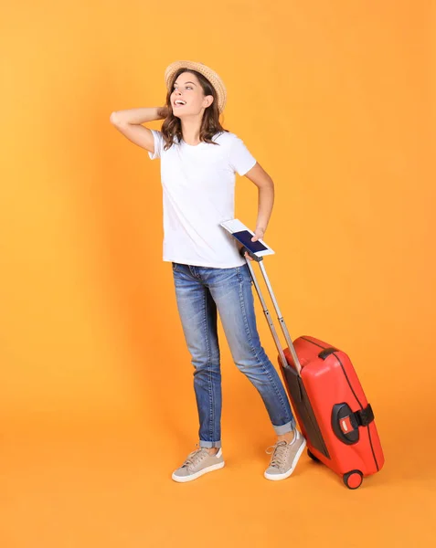 Jeune fille touristique en vêtements décontractés d'été, avec valise rouge, passeport, billets isolés sur fond beige . — Photo