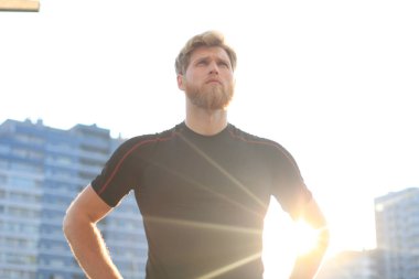 Açık havada duran süre çalıştırmadan önce germe yapan yakışıklı genç erkek egzersizleri.