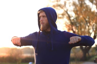 Açık havada duran süre çalıştırmadan önce germe yapan yakışıklı genç erkek egzersizleri.