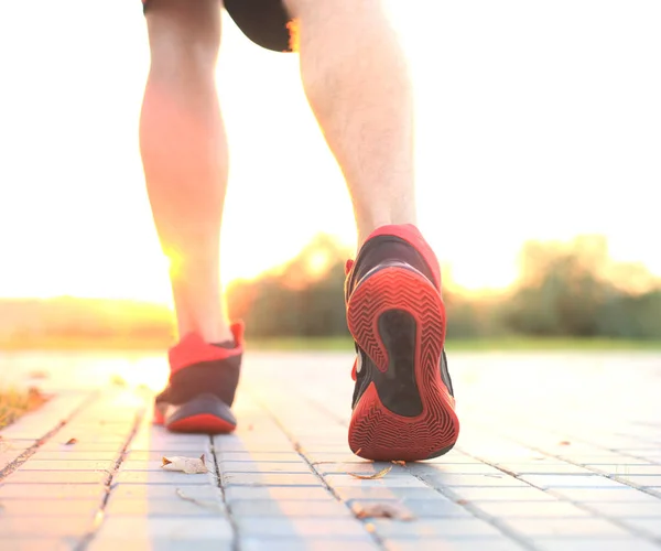 Runner voeten draait op de weg close-up op schoen, buiten bij zonsondergang of zonsopgang. — Stockfoto