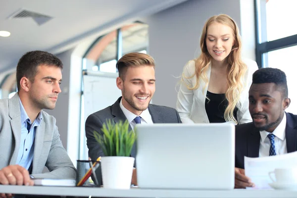 L'équipe d'affaires de démarrage sur la réunion dans l'intérieur lumineux moderne de bureau et travaillant sur l'ordinateur portable. — Photo