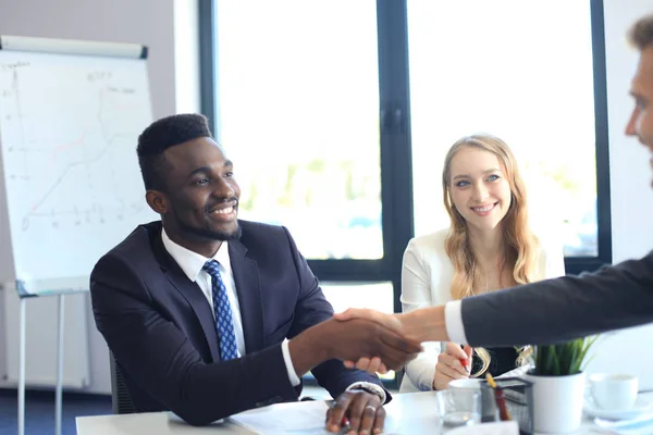 Zakenmensen schudden elkaar de hand tijdens een vergadering. — Stockfoto