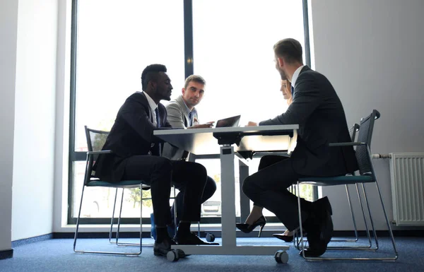 Gente de negocios discutiendo algo mientras están sentados juntos en la mesa . —  Fotos de Stock