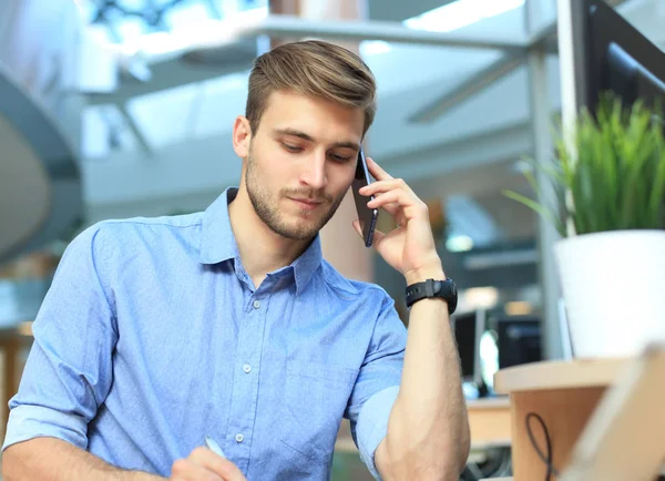 Uśmiechający Się Biznesmen Siedzi Przy Użyciu Telefonu Komórkowego Biurze — Zdjęcie stockowe