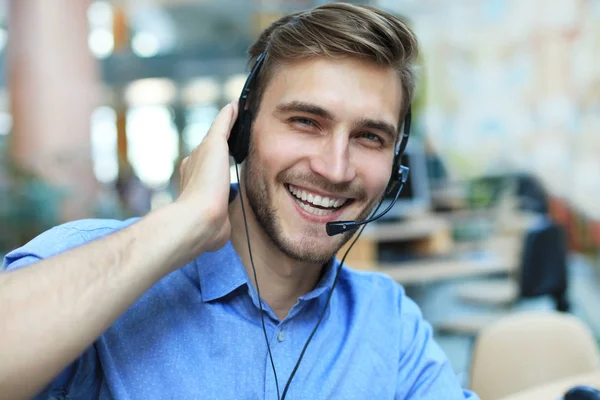 Freundlich lächelnde hübsche junge männliche Callcenter-Betreiber. — Stockfoto