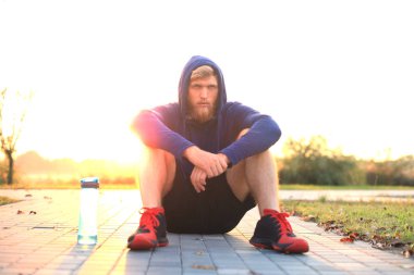 Parkta koşu gündoğumu veya günbatımı sonra dinlenme çalıştırdıktan sonra yakışıklı delikanlı.