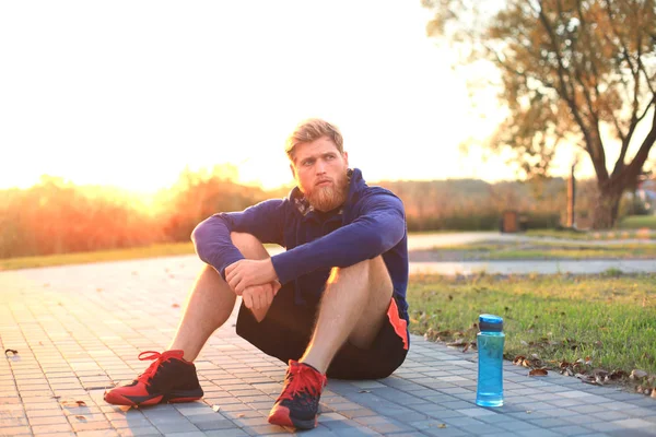 Parkta koşu gündoğumu veya günbatımı sonra dinlenme çalıştırdıktan sonra yakışıklı delikanlı.