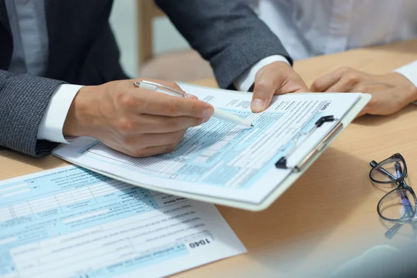 Man vs individuele aangifte inkomstenbelasting invullen, fiscale 1040 aan tafel. — Stockfoto