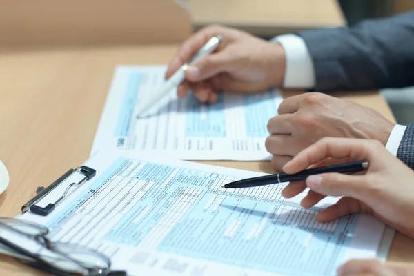 Man vs individuele aangifte inkomstenbelasting invullen, fiscale 1040 aan tafel. — Stockfoto