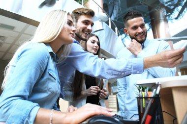 Ofis Masası oturma ve Pc vasıl birlikte bakarken bir şey tartışırken rahat kıyafet içinde gençlerin Grup.